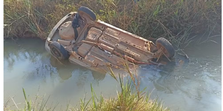 Filho percebe que carro dos pais estava demorando, voltou e viu o veículo com as rodas pro alto dentro de rio