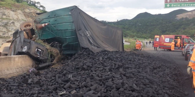 Carreta carregada de carvão tomba e fica pendurada em viaduto da BR-381, em Caeté